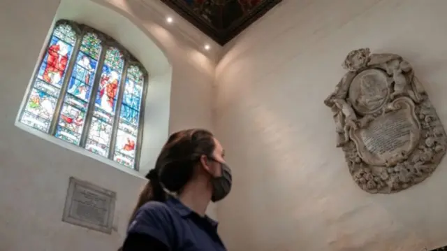Someone looking at he memorial to Tobias Rustat in Jesus College, Cambridge, UK