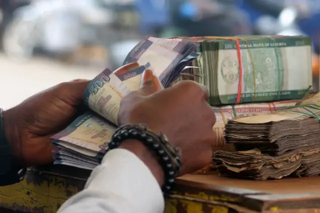 A money changer counts banknotes in Monrovia, Liberia, 21 September, 2018.
