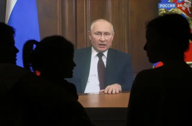 A Russian family watches as Russian President Vladimir Putin addresses the nation. Photo: 21 February 2022