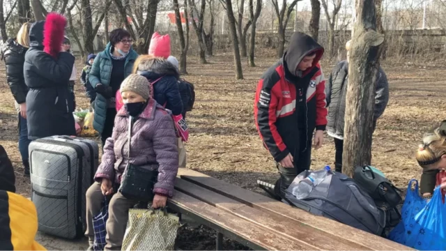 Evacuees with suitcases and belongings