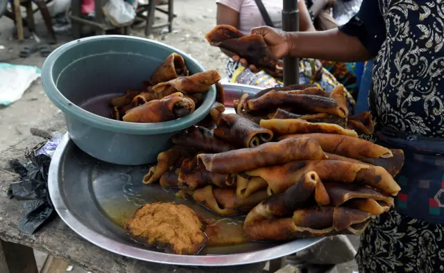 A woman tries to buy cow skin, Nigeria's delicacy popularly called Pomo, displayed at Ketu Market in Lagos, on July 24, 2020