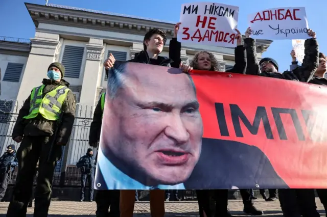 Ukrainians hold banners with photos of Russian President Vladimir Putin as they protest outside the Russian embassy in Kyiv. Photo: 22 February 2022