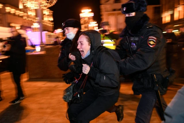 Police officers detain a woman during a protest against Russia's invasion of Ukraine in Moscow