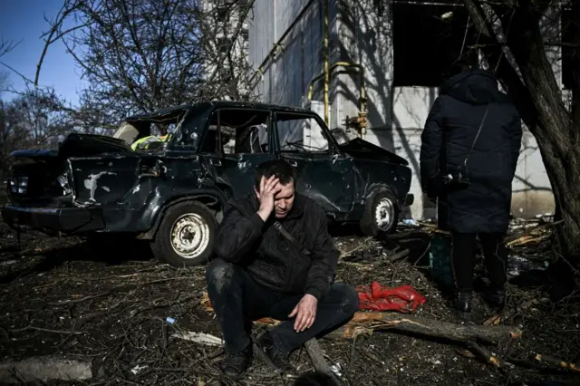 Man beside bombed car