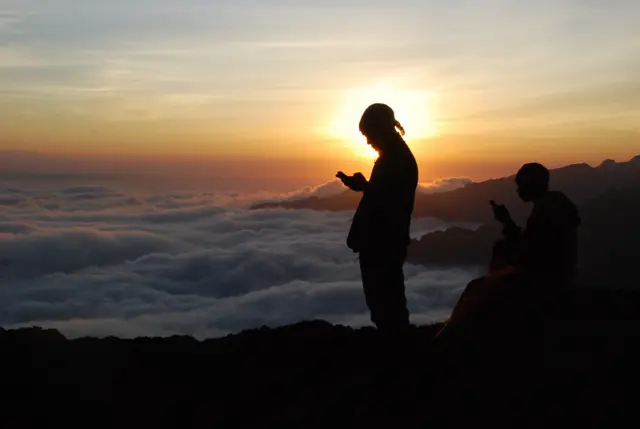 A Tanzanian porters uses a phone half way up Mt Kilimanjaro