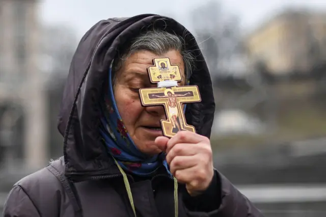 woman prays in kyiv's independence square