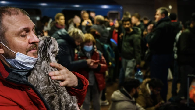 A man tries to calm his cat while sheltering underground in Kharkiv