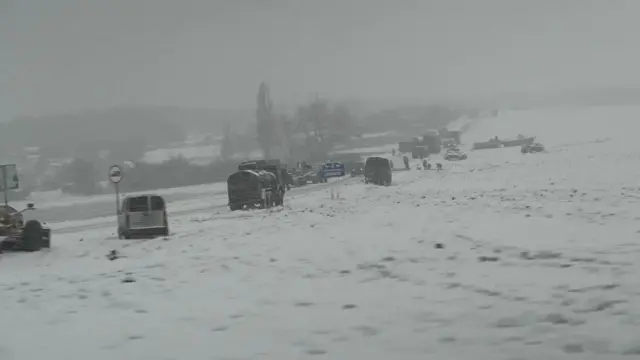 Military vehicles parked in a field to the side of the main road from Belgorod in Russia to Kharkiv in Ukraine