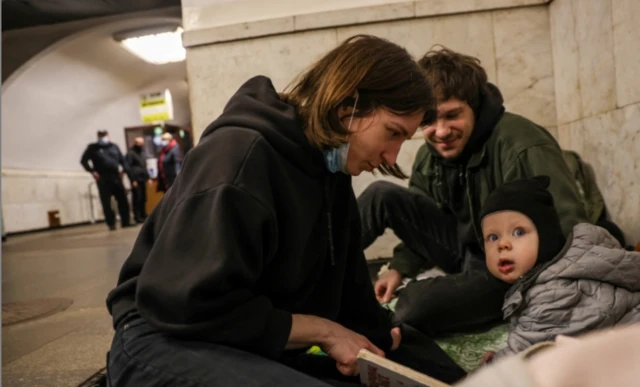 A young family shelters in an underground metro station in Kyiv