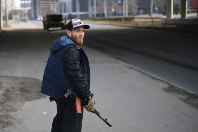 A volunteer holds an automatic rifle in Kyiv on Friday