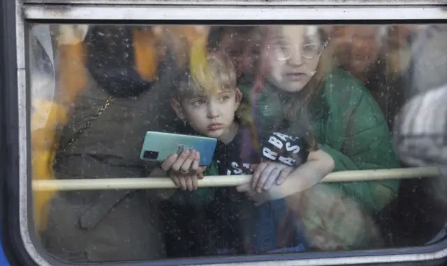 A woman and child look out from an evacuation train leaving Kyiv