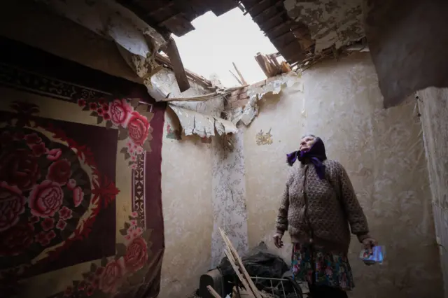 A woman in a house badly damaged by shellfire in Gorlovka Ukraine