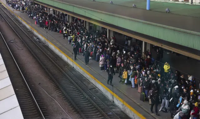 People wait at Kyiv train station to leave the capital