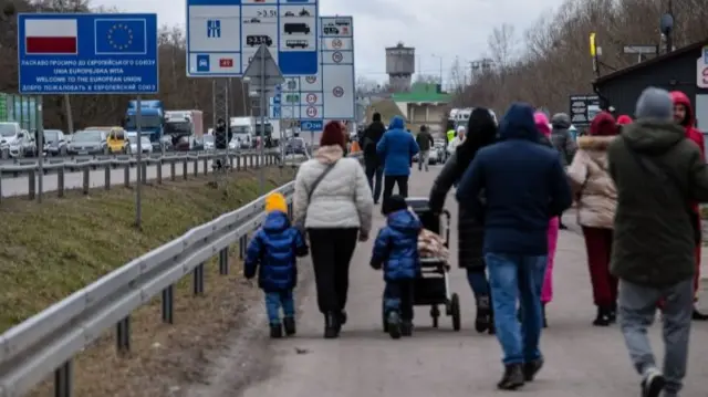 People crossing the border from Ukraine into Poland