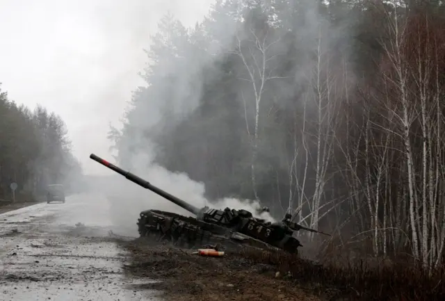 Smoke rises from a Russian tank destroyed by the Ukrainian forces in the Luhansk region