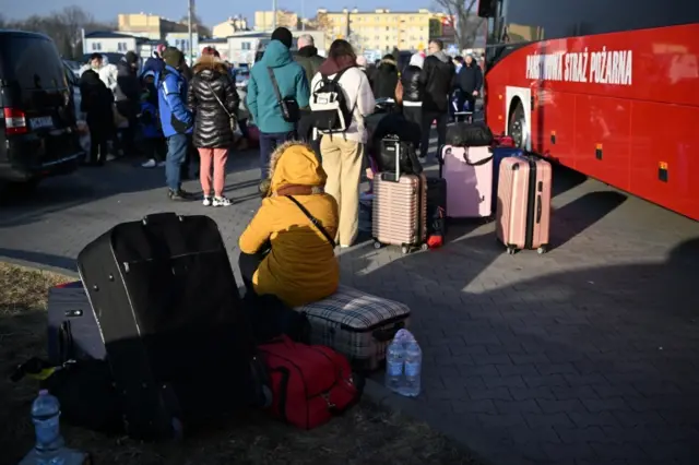 People arrive at a reception centre for war refugees from Ukraine set up in a car park in Przemysl, Poland