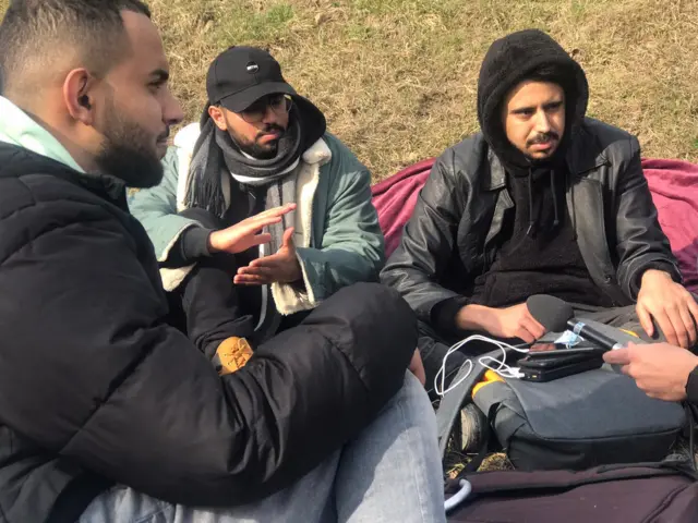 Yemeni students sit on the ground