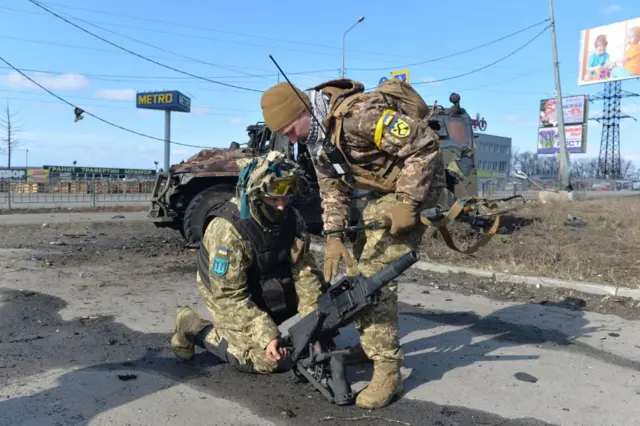 Ukrainian Territorial Defence fighters test the automatic grenade launcher taken from a destroyed Russian infantry mobility vehicle GAZ Tigr