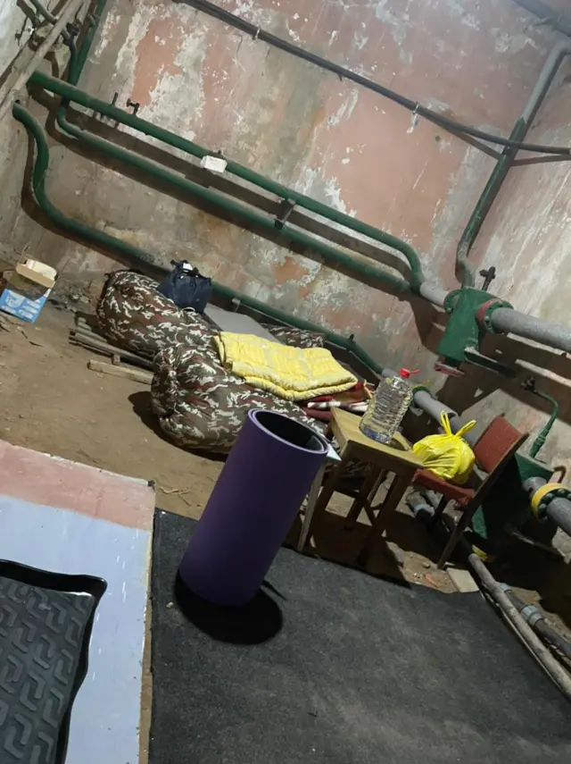 Camping chairs and makeshift beds in the basement on an apartment building in the city of Kharkiv