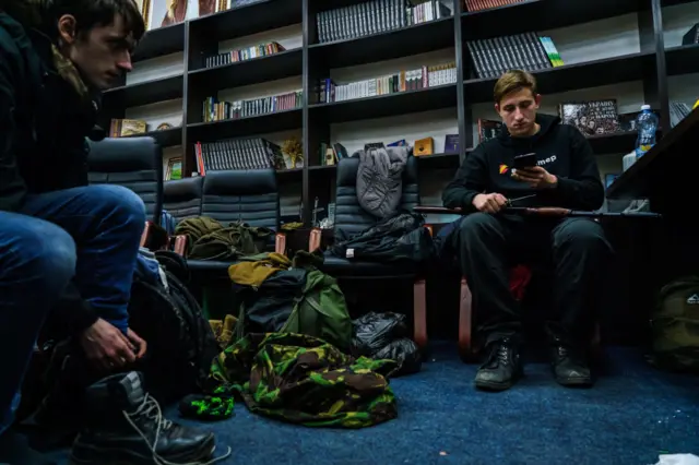 Recruits to Ukraine's Territorital Defence units sit and wait in an outpost in Kyiv, Ukraine on Saturday 26 February 2022