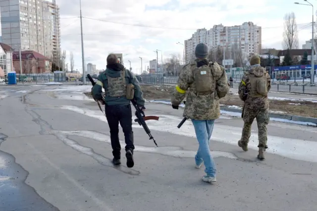 Ukrainian Territorial Defence fighters patrol the streets