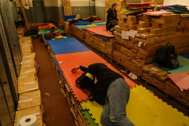 Volunteer sign-ups sleeping on cardboard and foam mats in a bunker in Kyiv on Saturday night