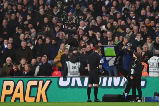 Referee Stuart Atwell checks VAR