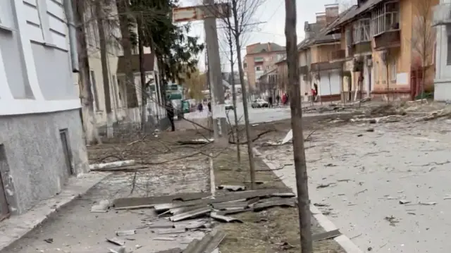 Damage along a road in Chernihiv, there is debris on the ground.