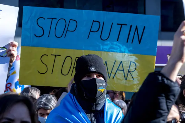 Demonstrators hold banners with written messages against Russian President Vladimir Putin during a demonstration against Russia's invasion of Ukraine held in front the building of the Permanent Mission of Russia to the EU on February 26, 2022 in Brussels, Belgium