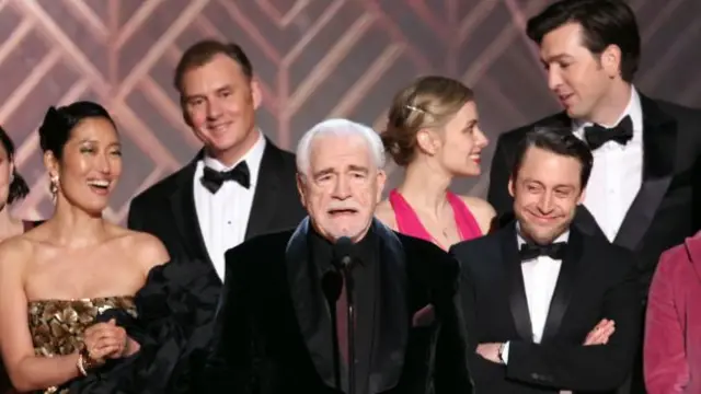 Actor Brian Cox, surrounded by the cast of Succession, accepting the award for Outstanding Performance by an Ensemble in a Drama Series