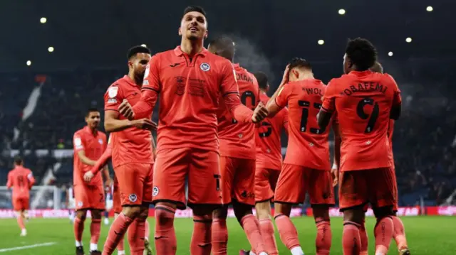 Swansea celebrate goal, as Joel Piroe gestures towards fans