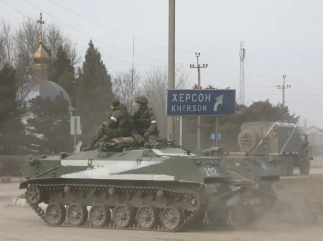 Russian servicemen ride on an Russian Army military armoured vehicle