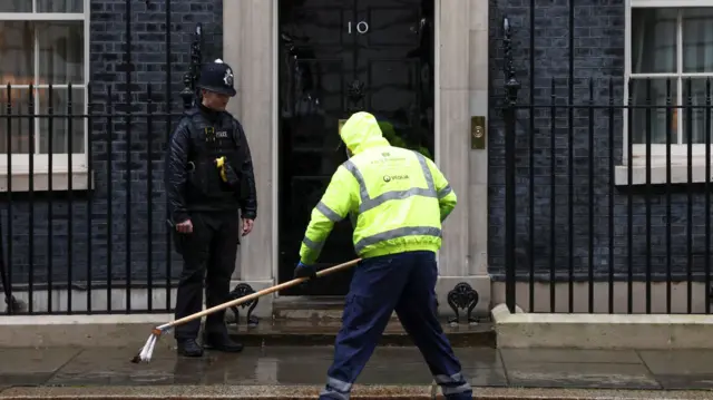 A cleaner sweeps Downing Street