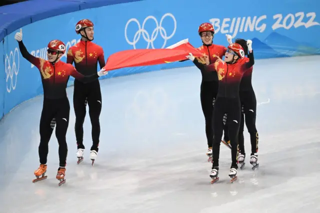 China celebrating with their flag doing a lap of honour