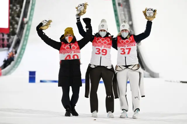 Ursa Bogataj, Nika Kriznar and Katharina Althaus celebrate their podium finish