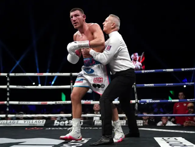 Liam Williams is held back by the referee