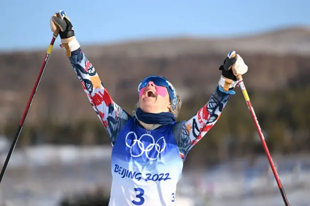 Therese Johaug celebrating as she crosses the finish line