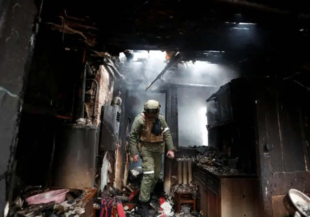 A pro-Russian militiaman inspected a house damaged by shelling