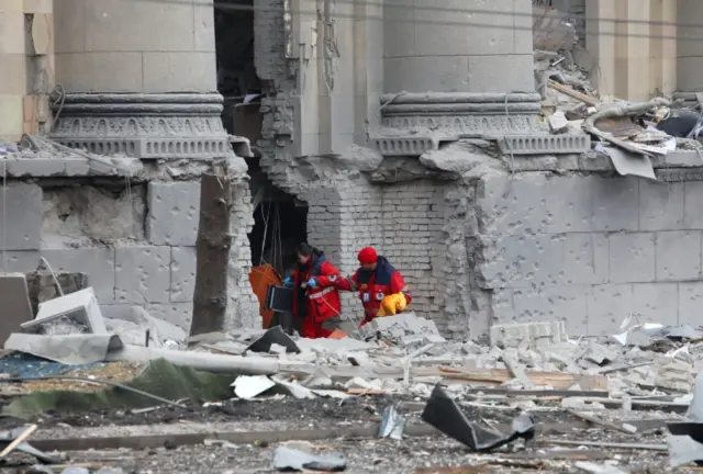 Medics walk outside the regional administration building, which city officials said was hit by a missile attack, in central Kharkiv, Ukraine, March 1