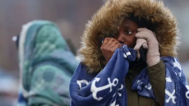 woman from Western Africa cries while taking on the phone after fleeing Ukraine