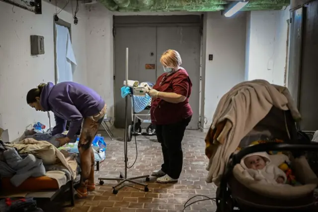 A nurse checks a baby being treated at a pediatrics center after unit was moved to the basement of the hospital