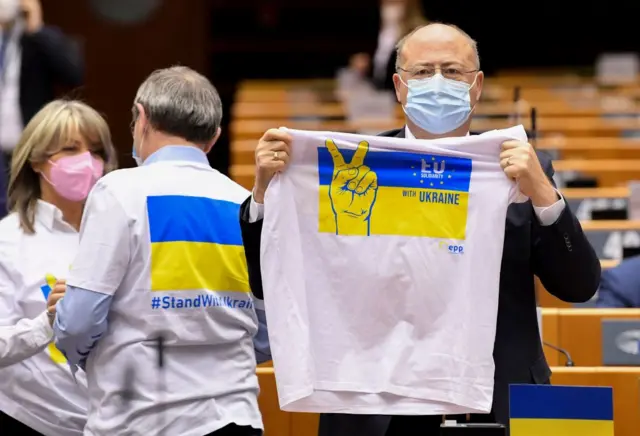 A member of European parliament holding shirt with Ukraine flag on it