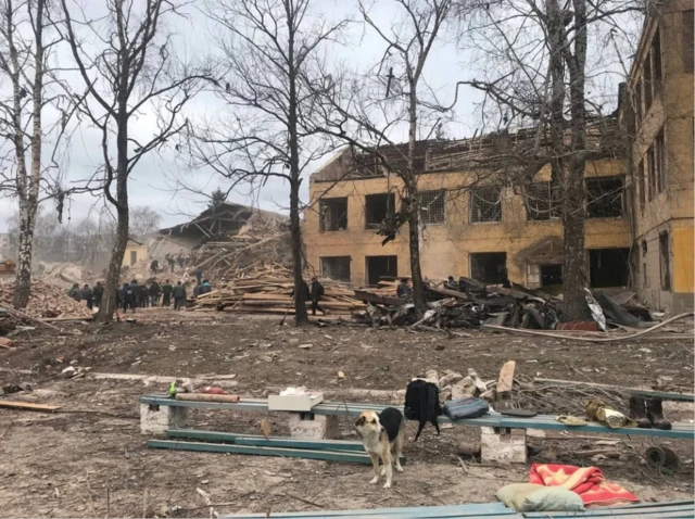 A crowd gathers next to the collapsed part of a military base struck by Russian artillery