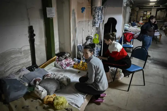 Women look after their babies at the pediatrics center after the unit was moved to the basement of the hospital which is being used as a bomb shelter, in Kyiv on February 28, 2022