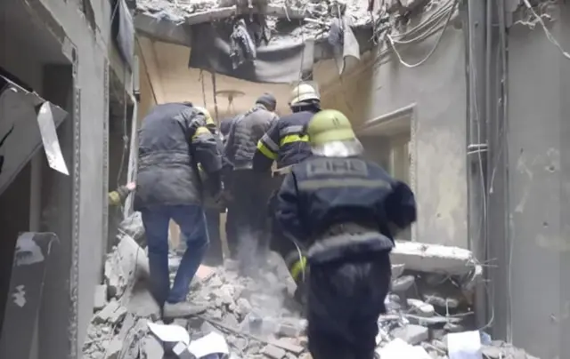 Emergency Services crew search building after alleged Russian missile attack on Freedom Square in Kharkiv