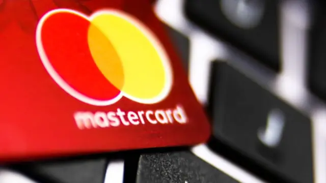 MasterCard logo on a credit card and a laptop keyboard are seen in this illustration photo