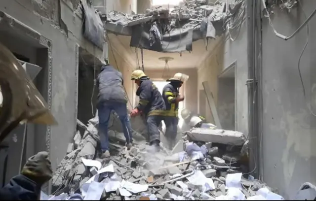 Emergency Services crew search building after alleged Russian missile attack on Freedom Square in Kharkiv