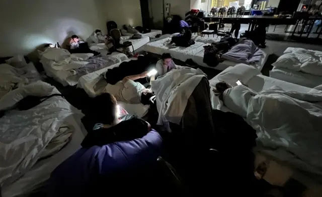 People check phones will sheltering in a basement