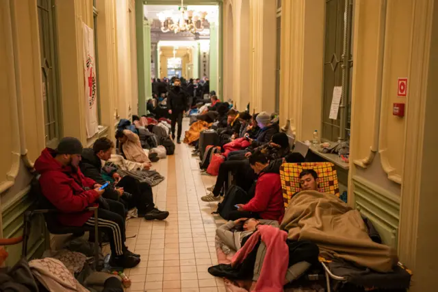 People sleep on chairs and on the floor of Przemysl station, in Przemysl, Poland.