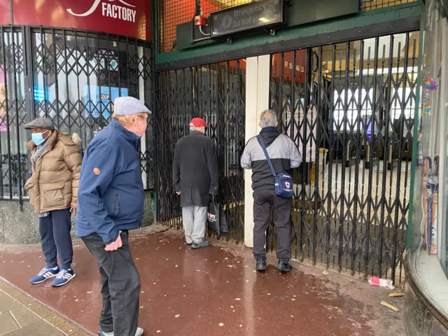 Commuters outside a gated-off Tube station